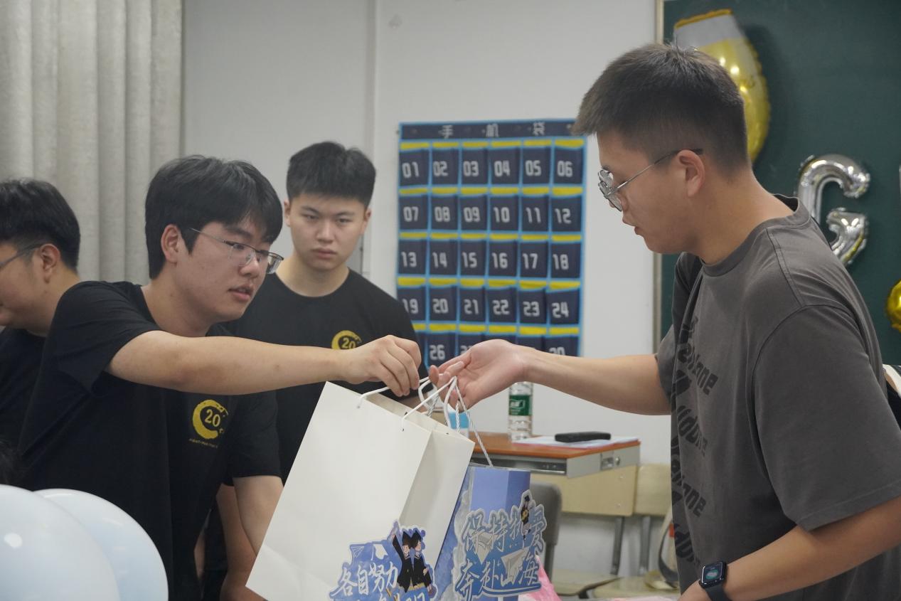 图：团学成员给毕业生发放毕业礼物